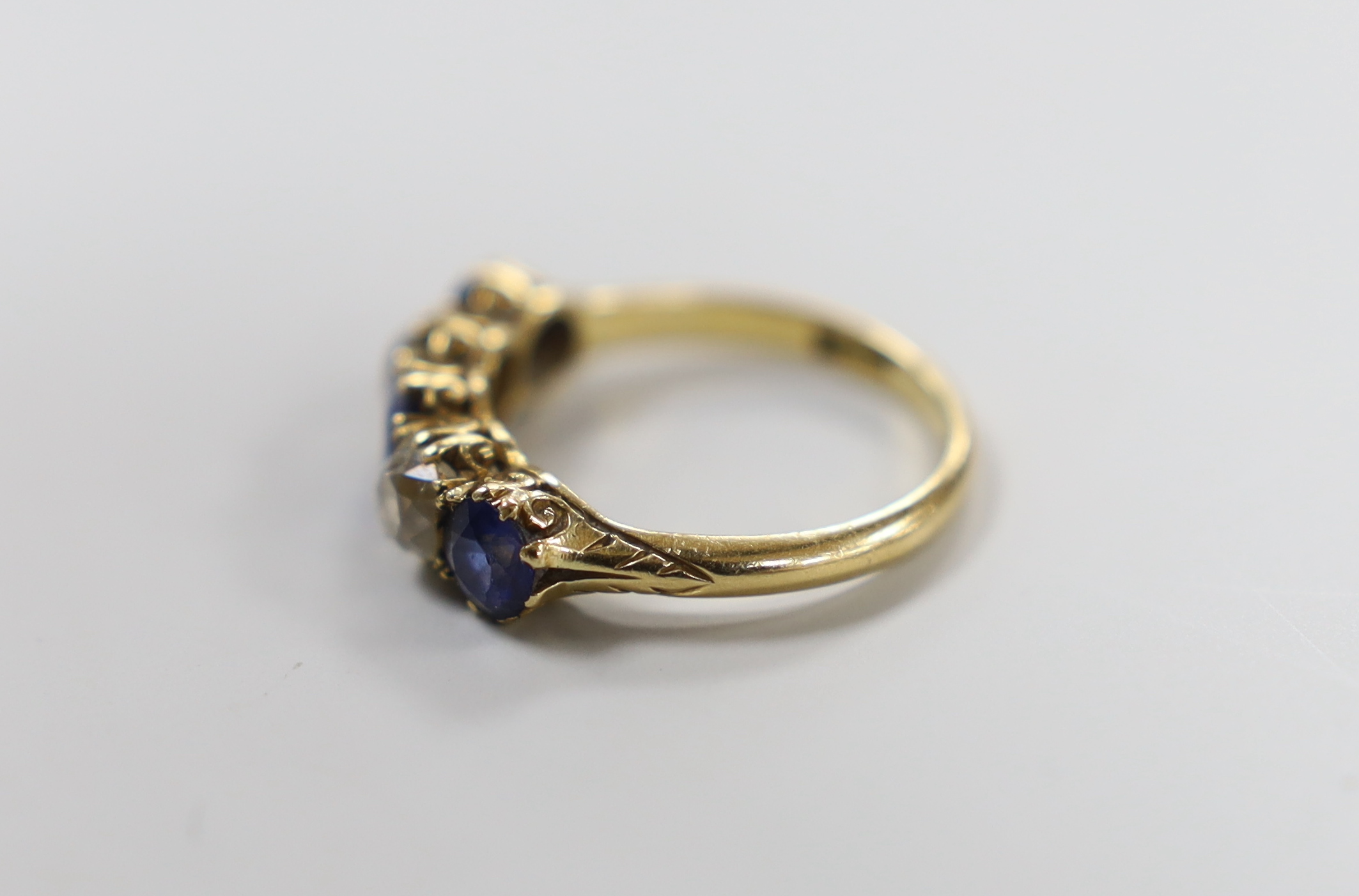 An 18ct gold, three stone blue paste and two stone diamond set half hoop ring